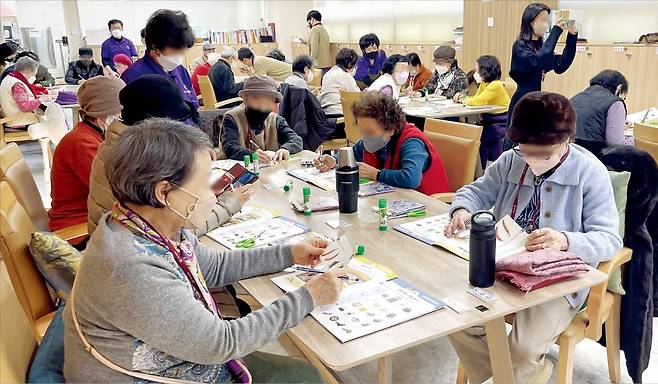 지난달 28일 경기 성남시 구미동 대교뉴이프 데이케어센터 분당센터를 찾은 노인들이 요양보호사의 지도에 따라 미술 수업을 듣고 있다. 황정환 기자
