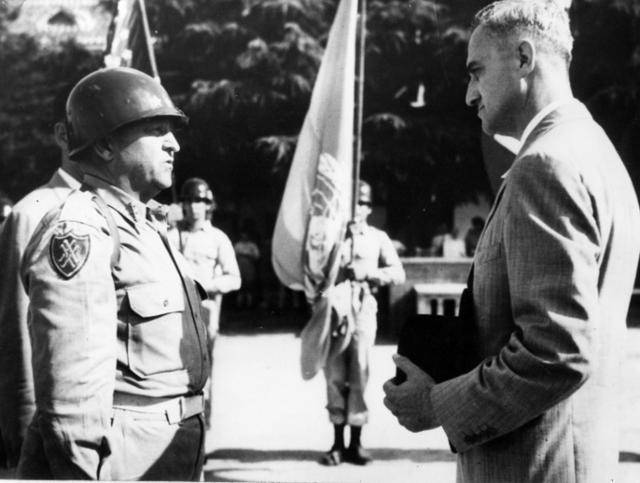 미 8군사령관 월튼 워커 중장이 1950년 7월 24일 트리그브 할브란 리 유엔 사무총장의 특사인 앨퍼드 카친으로부터 유엔기를 넘겨받고 있다. 유엔은 북한의 남침을 불법으로 규정하고 한국전쟁에 유엔군을 파병했다. 해리 트루먼 도서관(공공도메인)