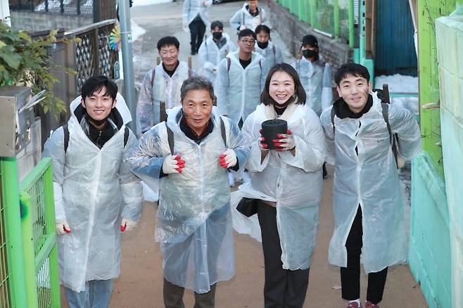 이학재 인천국제공항공사 사장(앞줄 왼쪽 두번째)이 지난해 12월 인천 미추홀구 학익동에서 진행된 '인천공항 합동봉사단 연탄봉사'에 참여한 봉사단원들과 연탄을 나르고 있다. 인천국제공항공사 제공