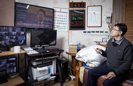 불경기를 묵묵히 견디던 자영업자에게 비상계엄은 불난 집에 기름을 붓는 것과 같았다. 충남 천안에서 모텔을 하는 함장수씨가 지난달 4일 자신의 사무실에서 헌법재판소의 대통령 탄핵 심판 관련 뉴스를 보고 있다. 전민규 기자