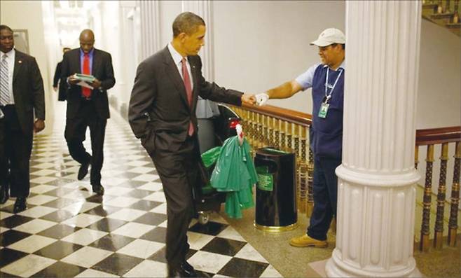 백악관의 청소부와 주먹 인사를 나누는 버락 오바마. 2008년 민주당 대선 후보로 지명된 후, 아내 미셸과 나눈 이 사소한 비언어적 인사법은 대통령 오바마의 새로운 정치를 상징하는 것이 되었다. (옛 트위터 갈무리)