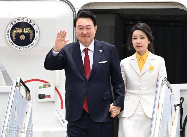 윤석열(왼쪽) 대통령과 김건희 여사가 지난해 7월 8일 북대서양조약기구(NATO·나토) 창설 75주년 정상회의 참석에 앞서 미국 하와이 호놀룰루의 히캄 공군기지에 도착해 전용기인 공군 1호기에서 내리며 손을 흔들고 있다. 호놀룰루=왕태석 선임기자