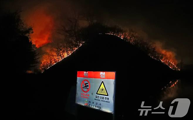 23일 오후 어둠이 짙게 깔린 경북 의성군 의성읍 업리 동사곡지(저수지) 뒤편 야산에 거대한 산불이 확산하고 있다. 2025.3.23/뉴스1 ⓒ News1 공정식 기자