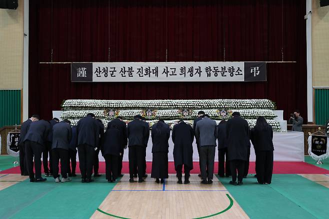 24일 오전 경남 산청 산불로 숨진 희생자 4명의 합동분향소가 차려진 창녕군 창녕읍 창녕군민체육관에서 추모객들이 묵념하고 있다. 연합뉴스