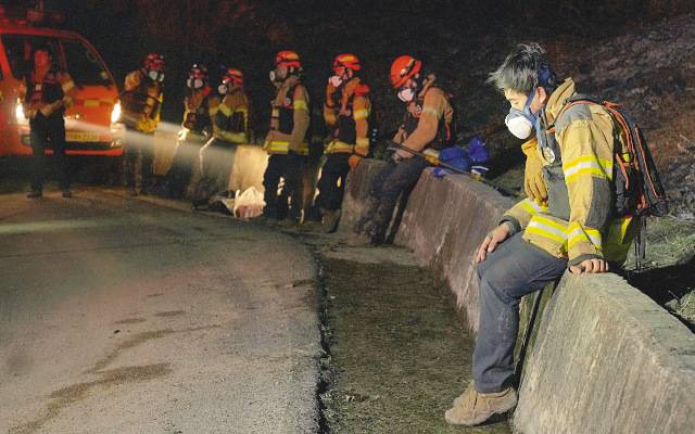 경북 의성 대형 산불과 사투를 벌이고 있는 진화대원들이 24일 잠시 휴식을 취하고 있다. 옷 전체와 머리에 재가 묻어 있는 대원들 모습에 지친 표정이 역력하다. 이들은 위험을 감수하고 화재 현장에 뛰어들지만 처우 등은 열악한 것으로 전해졌다. 연합뉴스