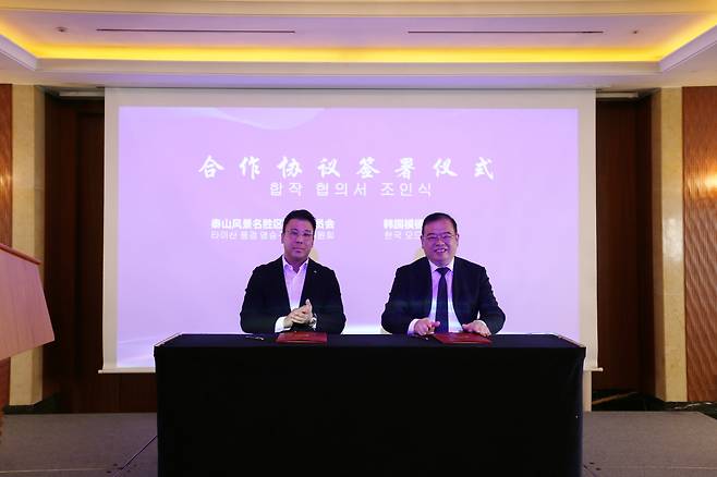 우준열 모두투어 신임 사장(왼쪽)과 이봉 태산 관광지 관리위원회 부주임이 업무협약식을 체결하고 기념 촬영을 하고 있다.