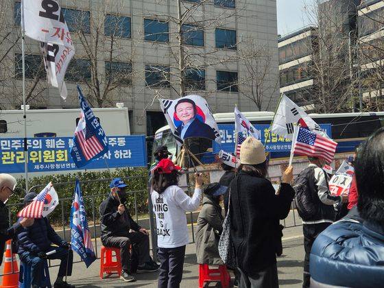26일 서울 서초동 일대 윤석열 대통령 지지자가 대통령 사진과 태극기를 흔들고 있다. 오소영기자