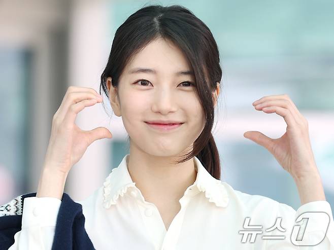 배우 수지가 해외 일정을 위해 26일 인천국제공항을 통해 싱가포르로 출국하기 전 볼 하트로 인사를 전하고 있다. ⓒ News1 권현진 기자