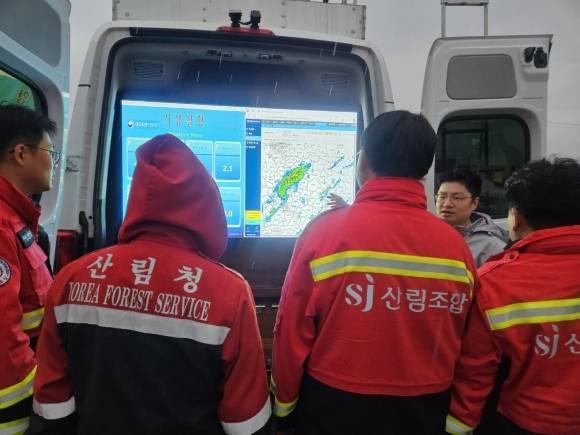 ‘의성에 기다리던 비’ - 27일 경북 의성군 산림청 산불 현장 지휘 본부 일대에 비가 내리자 산림청 관계자들이 레이더에 뜬 비구름을 보며 기뻐하고 있다. 2025.3.27 연합뉴스