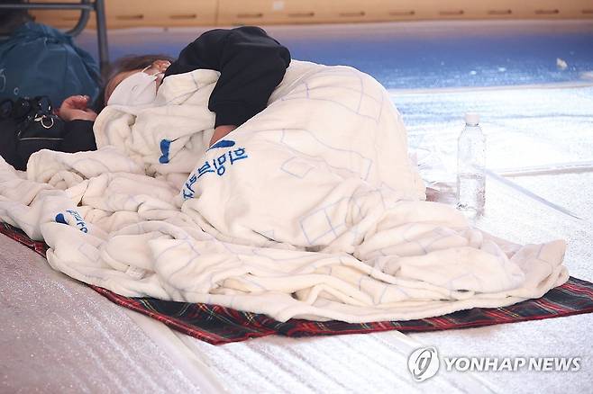 차가운 대피소 생활 (안동=연합뉴스) 손형주 기자 = 27일 경북 안동시 길안면 길안중학교에 마련된 산불대피소에 주민들이 휴식을 취하고 있다. 2025.3.27 handbrother@yna.co.kr