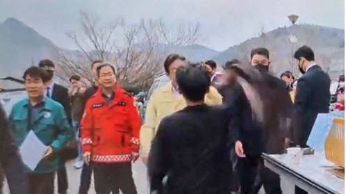 경북 영양군 이재민 대피소 인근에서 검은 옷을 입은 남성이 이재명 더불어민주당 대표를 향해 옷을 휘두르는 모습. 연합뉴스TV