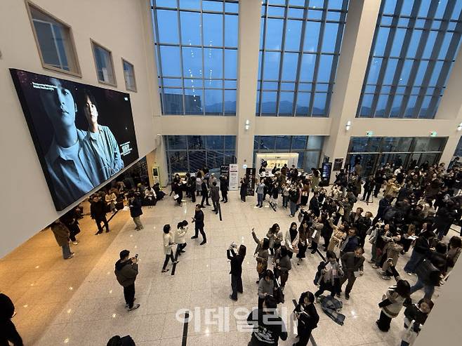 ‘2025 통영국제음악제’가 28일 경남 통영국제음악당에서 막을 올렸다. 개막공연 ‘통영페스티벌오케스트라Ⅰ’을 관람하러 온 관객들이 로비에서 피아니스트 임윤찬이 출연하는 홍보 영상을 사진으로 촬영하고 있다. (사진=장병호 기자)