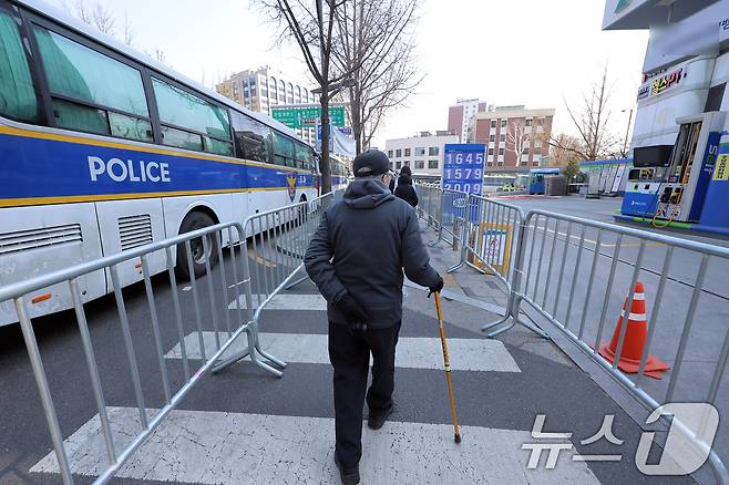 윤석열 대통령 탄핵심판 선고를 하루 앞둔 3일 서울 종로구 헌법재판소 인근을 지나는 어르신이 펜스가 쳐진 길을 걷고 있다. 2025.4.3/뉴스1 ⓒ News1 박정호 기자