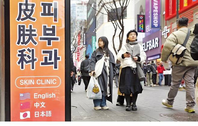 2일 서울 명동 관광 거리 일대에서 외국인 관광객들이 피부과 병원 앞을 지나가고 있다. /김범준 기자