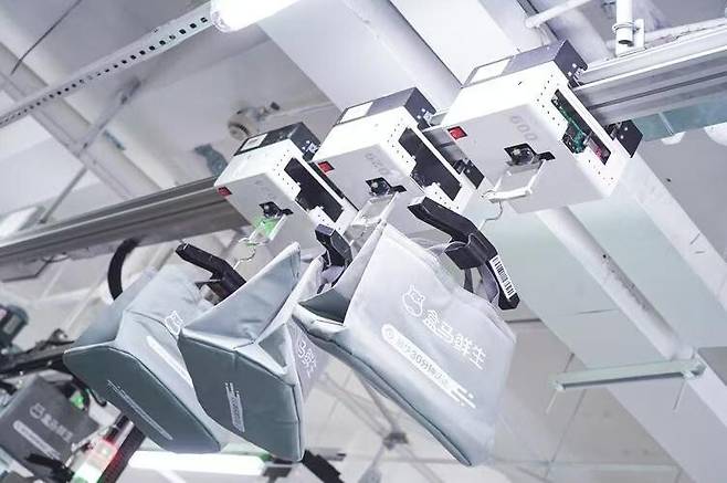 알리바바 신선식품 체인 허마셴성의 매장마다 설치된 ‘현수형 컨베이어+AI 스케줄링 시스템’은 매장 내 상품 배송 작업원의 하루 이동 거리를 12㎞에서 2.8㎞로 줄이고 신선제품 손실률을 4.7%에서 1.5%로 낮췄다. 브로드뷰 누리집