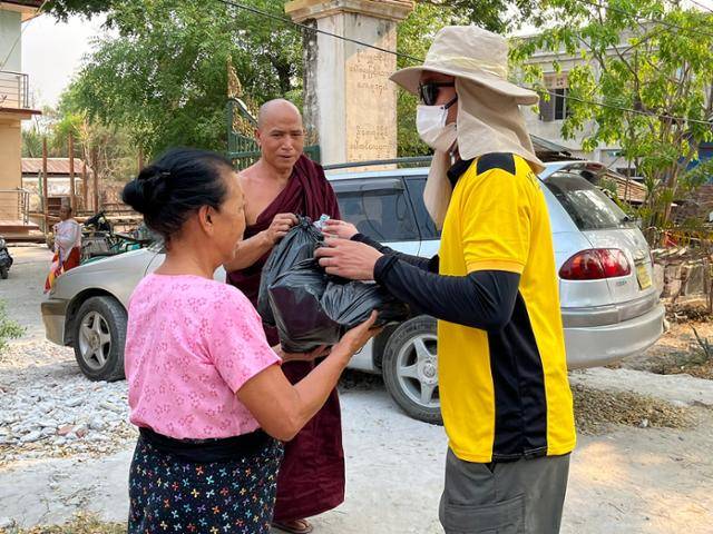 지난 3일 미얀마 사가잉 지진 피해 현장에서 자원봉사자가 주민들에게 생필품이 담긴 봉투를 건네고 있다. 사가잉=허경주 특파원