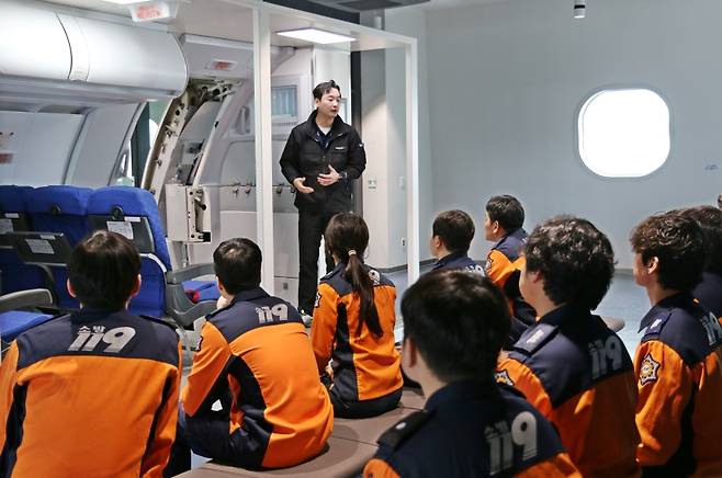 지난 9일 에어부산 사옥 훈련시설에서 부산소방재난본부 소방관들이 비상구 조작법을 배우고 있다. (에어부산 제공)