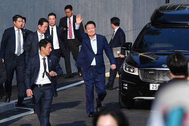 윤석열 전 대통령이 11일 서울 용산구 한남동 관저를 떠나며 지지자들에게 손을 흔들고 있다. 공동취재사진