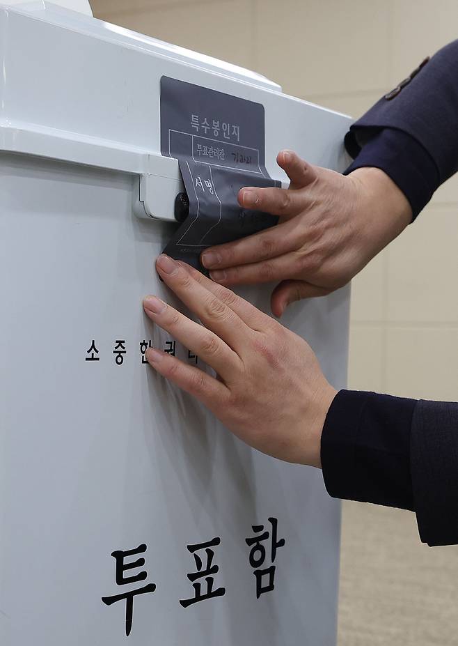 투·개표 시연이 있던 지난달 6일 경기 과천 선관위에서 선관위 관계자가 투표함 자물쇠 위에 특수봉인지를 부착하고 있다. 과천=이재문 기자