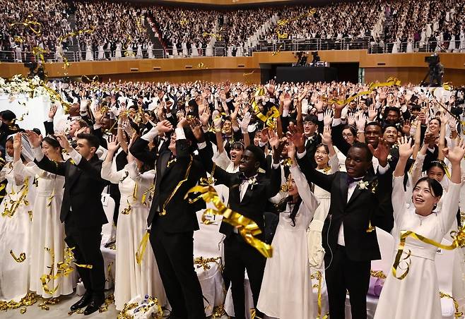 세계평화통일가정연합(옛 통일교)이 12일 경기 가평군 소재 청심평화월드센터에서 개최한 국제 합동결혼식에서 신랑·신부들이 밝은 표정으로 두손을 들고 있다.(세계평화통일가정연합 제공)
