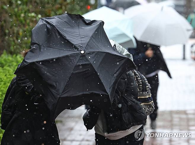 강풍에 우박까지 (서울=연합뉴스) 서대연 기자 = 서울 시내에 강풍과 함께 한때 우박이 내린 13일 서울 서초구 서울회생법원 인근에서 시민들이 우산 뒤로 몸을 숨기고 있다. 2025.4.13 dwise@yna.co.kr