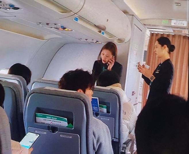 제주발 김포행 에어서울 RS902편 항공기에서 이륙 직전 한 승객이 비상문을 열자 승객과 승무원들이 이 승객을 제지한 뒤 조처를 취하고 있다. 독자 제공