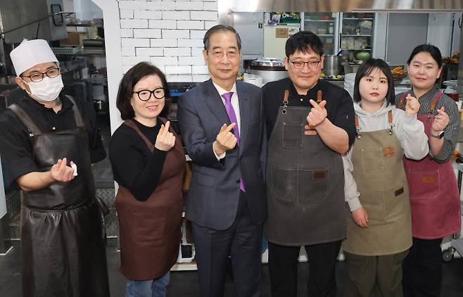 한덕수 대통령 권한대행 국무총리가 16일 결식 아동들에게 무료 점심을 제공해온 울산 뚠뚠이 돈가스에서 사장과 직원들을 격려하고 기념사진을 촬영하고 있다.(사진=연합뉴스 제공)