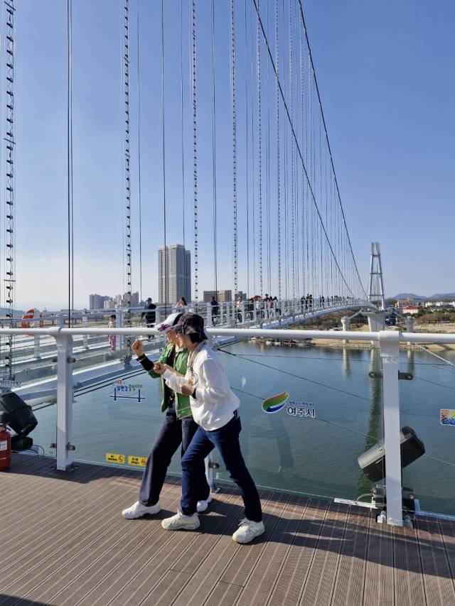 12일 오후 여주 남한강 출렁다리를 배경으로 기념촬영을 하고 있는 관광객들. 사진 = 손대선 기자
