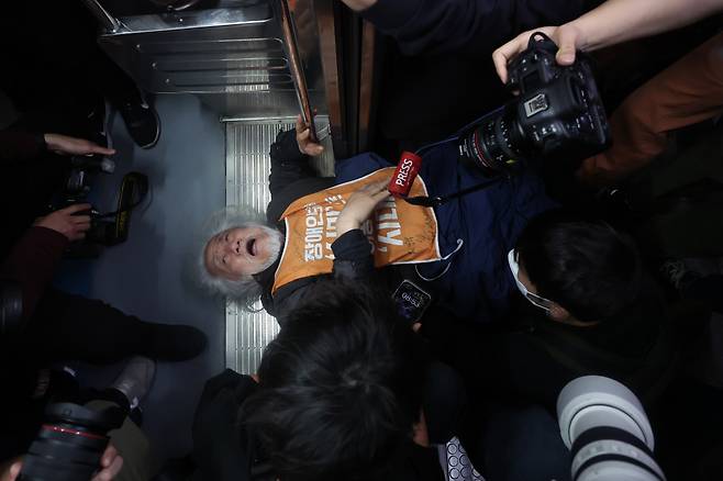 박경석 전국장애인차별철폐연대(전장연) 대표가 21일 서울지하철 4호선 혜화역에서 제62차 ‘출근길 지하철 탑니다’ 시위를 벌이던 중 시위를 제지하던 서울교통공사 관계자와 충돌해 넘어져 있다. 연합뉴스