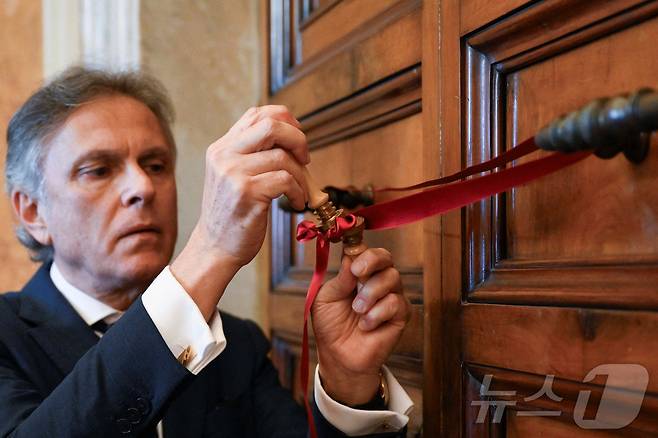 21일(현지시간) 프란치스코 교황이 선종한 가운데 흔히 바티칸 궁전 또는 교황궁이라고 불리는 교황의 관저가 붉은 리본으로 봉인됐다. 사진은 왁스씰을 붙이는 모습 2025.04.21 ⓒ 로이터=뉴스1 ⓒ News1 최종일 선임기자