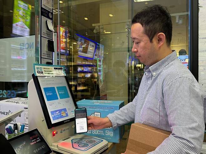 GS25 직원이 편의점 내 키오스크를 통한 택배 접수를 시연하고 있다. /GS리테일 제공
