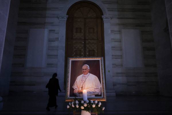 프란치스코 교황의 초상화 앞에 촛불이 타고 있다. 로이터 연합뉴스