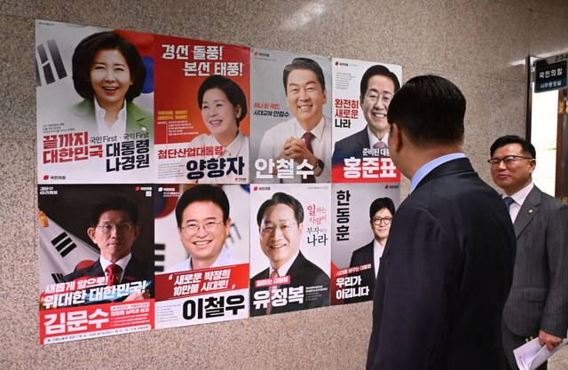 권영세 국민의힘 비상대책위원장이 21일 서울 여의도 국회 국민의힘 사무실 앞에 붙어 있는 대선 경선 후보자 8명의 포스터를 보고 있다. 권 위원장은 “과거에 연연하지 않겠다”며 당을 떠났던 인사들에게 복귀의 문을 열겠다고 밝혔다. 이병주 기자