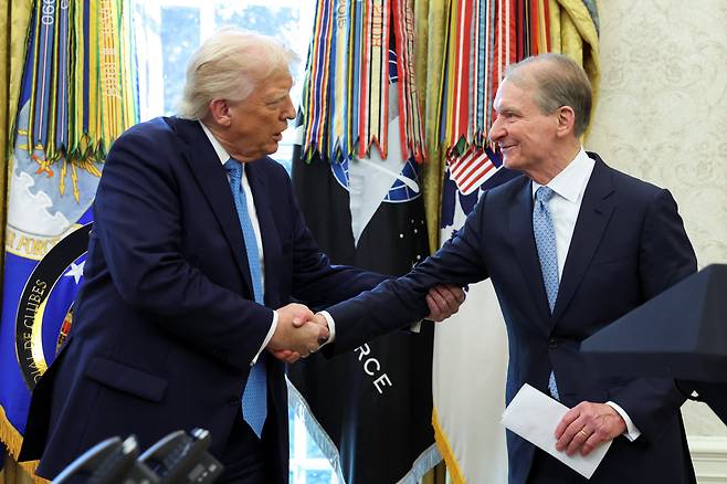 폴 앳킨스 신임 미 SEC 위원장(오른쪽)이 22일 백악관 집무실에서 도널드 트럼프 대통령과 악수를 하고 있다. /로이터 연합뉴스
