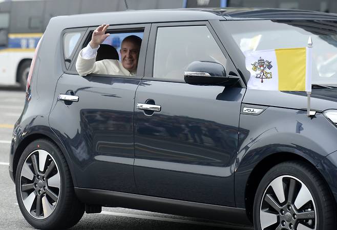 2014년 4박 5일 일정으로 한국을 방문한 프란치스코 교황이 서울공항에서 광화문을 거쳐 주한 교황 대사관으로 향하는 중 기아차 쏘울에 탑승해 시민들을 향해 손을 흔들고 있다./뉴스1