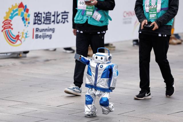 중국의 휴머노이드 로봇 0306 리틀자이언트가 18일 중국 베이징에서 열린 로봇하프마라톤대회에서 이동하고 있다. 로이터연합뉴스