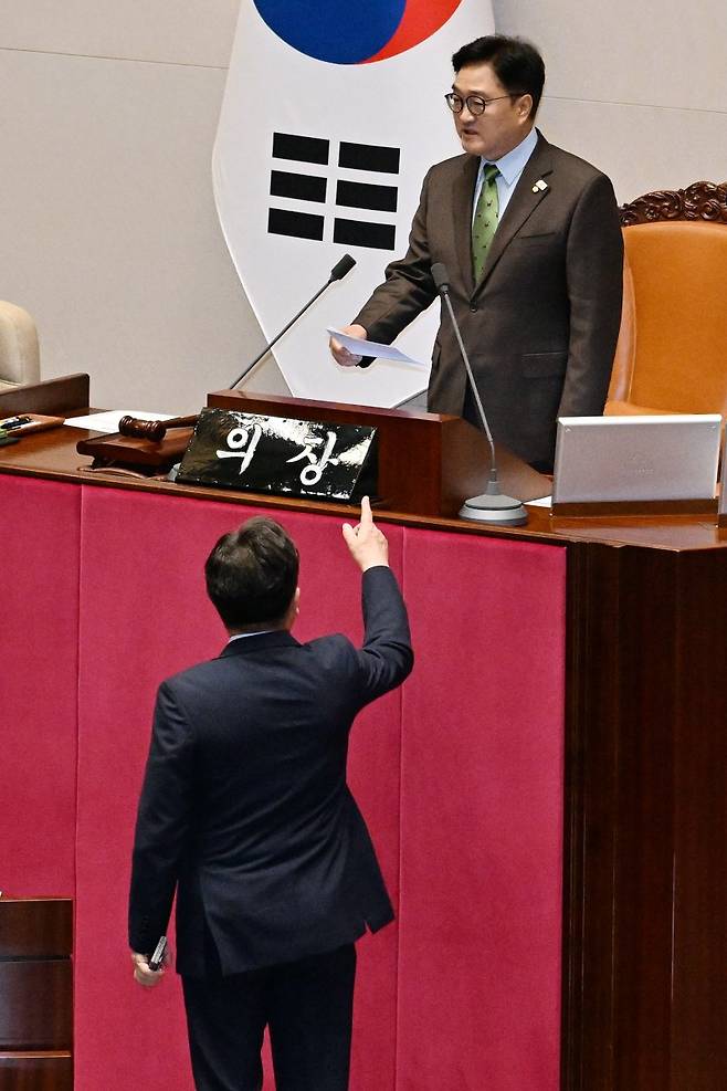 우원식 국회의장(위쪽)이 24일 열린 국회 본회의에서 한덕수 대통령 권한대행 국무총리의 추가경정예산안 시정연설 이후 한 권한대행에 대한 발언을 하자 권성동 국민의힘 원내대표가 연단 앞으로 나와 우 의장에게 항의하고 있다. 연합뉴스