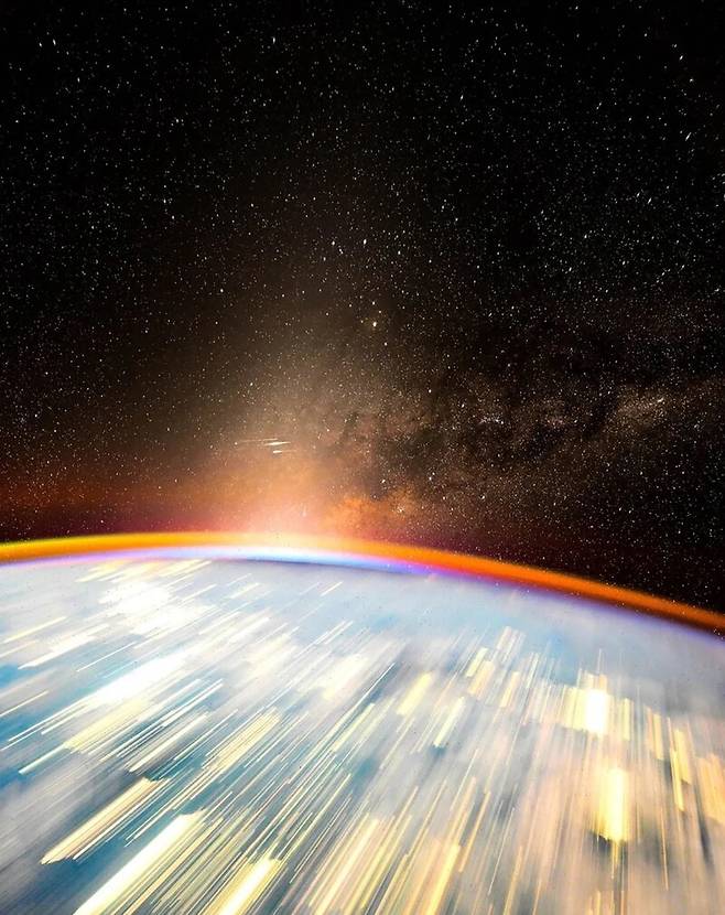 2025년 1월13일 촬영한 종합선물세트와도 같은 우주 사진이다. 우리 은하의 중심과 그 아래 황도광, 하늘을 가로질러 가는 스타링크 군집위성이 만든 줄무늬, 이제 막 떠오르려 하는 태양의 빛, 먼지의 빛반사로 인해 적갈색으로 빛나는 지구의 대기, 도시의 야간 조명이 만들어낸 지구 표면의 눈부신 줄무늬를 한꺼번에 감상할 수 있다. 황도광이란 황도, 즉 천구상에서 해가 지나는 길에 있는 우주 먼지가 햇빛을 산란하는 현상을 말한다. 돈 페티트