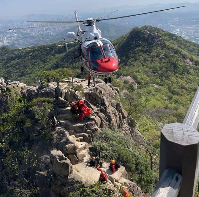 26일 오전 과천시 관악산 정상 부근에서 경기 소방 헬기가 환자를 인양하고 있다. 사진=경기도소방재난본부