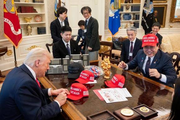 16일 관세 협상을 하기 위해 미국 백악관을 찾은 일본 측 협상 대표 아카자와 료세이(오른쪽) 경제재생상이 도널드 트럼프(왼쪽) 미 대통령이 사인한 마가(MAGA·미국을 다시 위대하게) 모자를 쓰고 웃고 있다. 백악관 제공