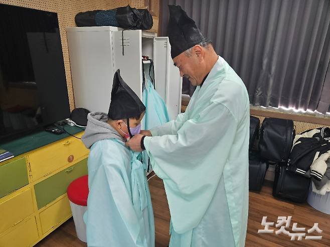 학생들이 전통복 체험을 하고 있다. 이종욱 할배샘이 옷을 정리해주고 있다. 반웅규 기자