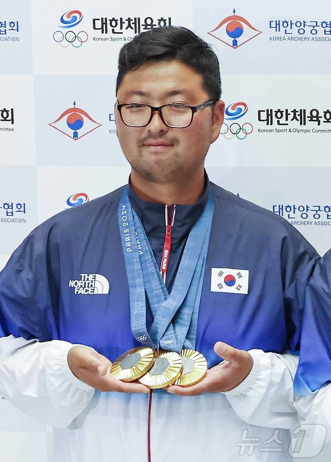 2024 파리올림픽 남자 양궁 3관왕에 오른 김우진이 인천국제공항을 통해 귀국해 금메달을 목에 걸고 포즈를 취하고 있다. 2024.8.6/뉴스1 ⓒ News1 민경석 기자