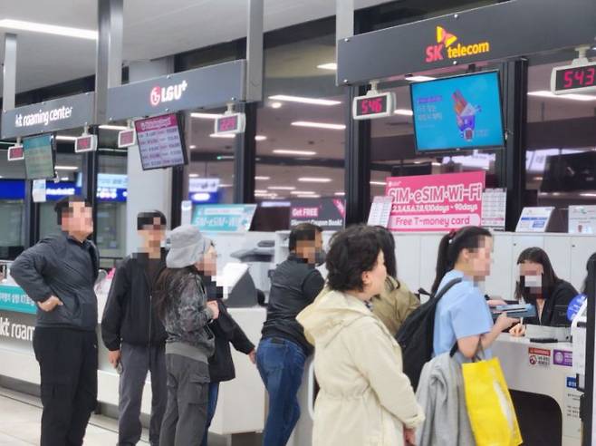 지난 27일 저녁 8시가 넘은 시간에도 김포공항 국제선 건물에 있는 SKT 로밍센터 앞에는 40여명의 가입자들이 유심 교체를 위해 대기하고 있었다. (사진=박유진 기자)
