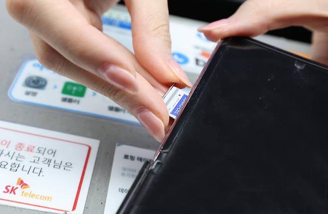 28일 오전 인천공항 제2터미널 SKT매장에서 해킹 공격으로 가입자 유심 정보가 탈취된 SK텔레콤 고객이 유심을 교체하고 있다. 뉴스1