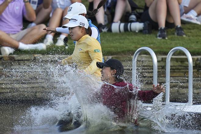 <yonhap photo-3378=""> 사이고 마오가 매니저 등과 함께 우승자만 할 수 있는 연못 입수 세리머니를 하고 있다. AP=연합뉴스</yonhap>