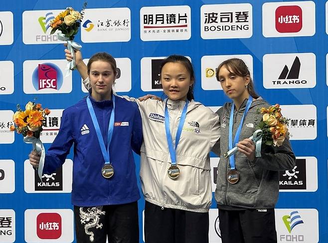 메달을 목에 걸고 환하게 웃고 있는 노스페이스 애슬리트팀 서채현 선수(가운데) . 노스페이스 제공