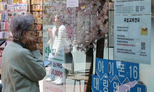 가입자 유심(USIM) 정보를 탈취당한 SK텔레콤이 유심 무료 교체 서비스를 시작한 지 이틀째인 29일 서울 시내 한 SKT 대리점에 시민들이 유심교체 안내판을 보고 있다. 정용일 선임기자 yongil@hani.co.kr