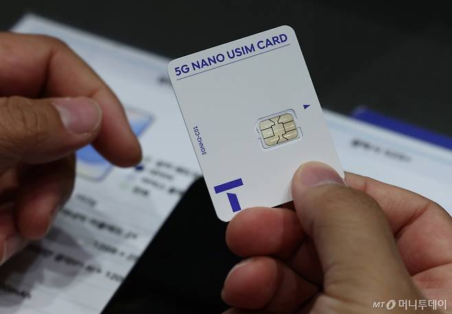 지난 28일 오전 서울 시내 한 SKT 대리점에서 한 이용자가 교체할 유심을 받고 있다. 해킹사고가 발생한 SKT는 사이버침해 피해를 막기 위해 28일 오전 10시부터 전국 2600여곳의 T월드 매장에서 희망 고객 대상 유심교체를 무료로 진행 중이다. / 사진=뉴시스