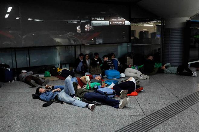 28일(현지시간) 스페인 마드리드 아토차 기차역에서 대규모 정전 사태로 발이 묶인 여행객들이 바닥에 누워 밤을 보낼 준비를 하고 있다. (사진=AFP)