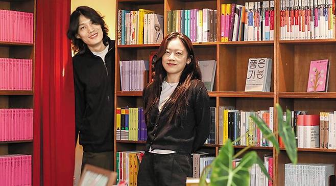 “무대 같은 공간으로 서점을 꾸미고 싶었어요.” 남편 권주영(왼쪽)씨가 서점에서 공연할 때 배우들이 대기하는 커튼 뒤에서 얼굴을 내밀고 있다. 오른쪽은 아내 박세인씨. /박성원 기자